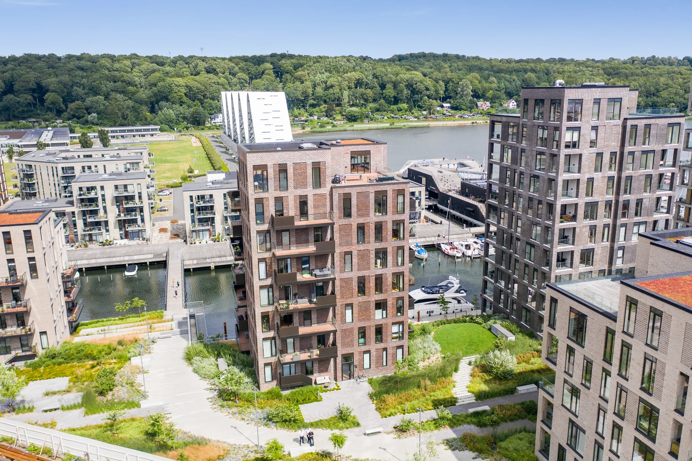 Bygning E på Havneøen 7 i Vejle – boligtårnet midt i dronefotoet med havnemiljøet og Vejle Fjord omkring sig